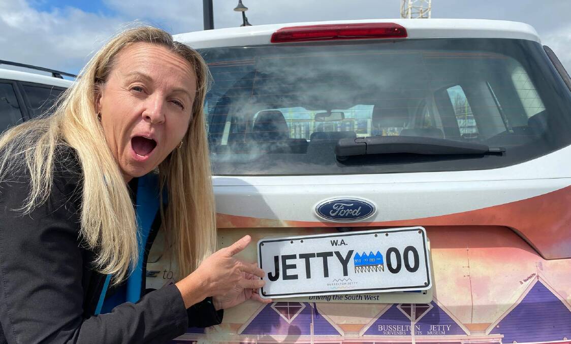 Busselton Jetty chief executive Lisa Shreeve showing off the new jetty number plates which will go to auction. Image supplied.